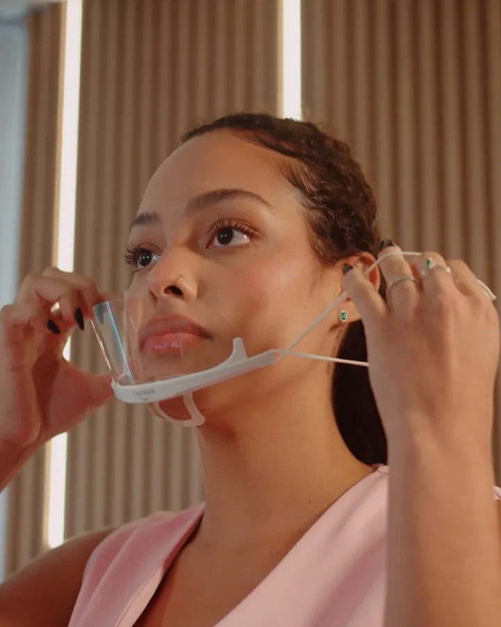 Sarah ajustando o protetor facial antes de atender